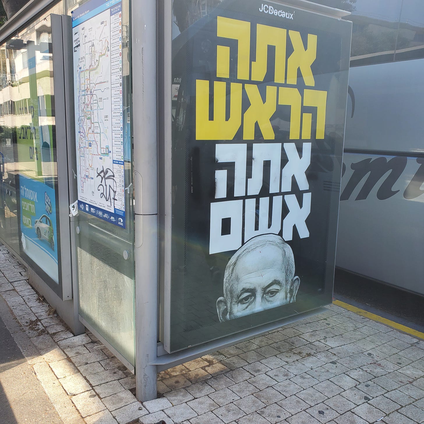 A poster showing Netanyahu's head and "You are the head, you are responsible" written in bold Hebrew letters above it. 