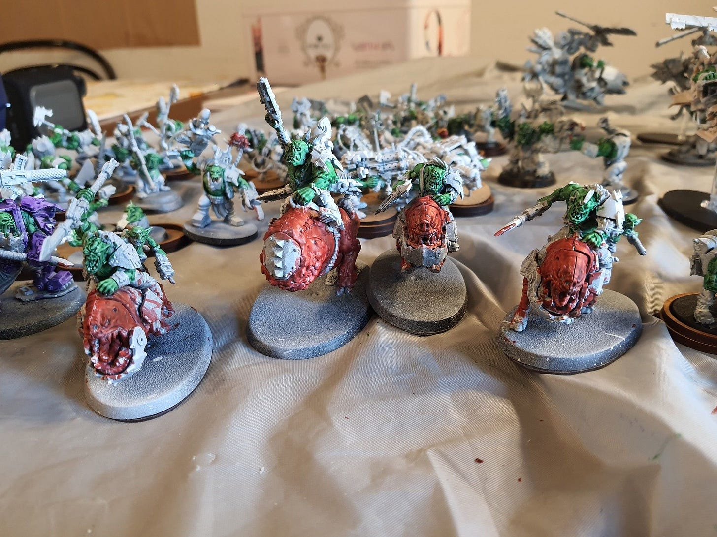 A squad of Squighog Boyz, led by a Nob on Smasha Squig. Their mounts are painted in Blood Angels Red, while the Orks and Grots are painted in contrast green. The rest of the minis remain base coated in white, but one of the spears has blood marks in it.