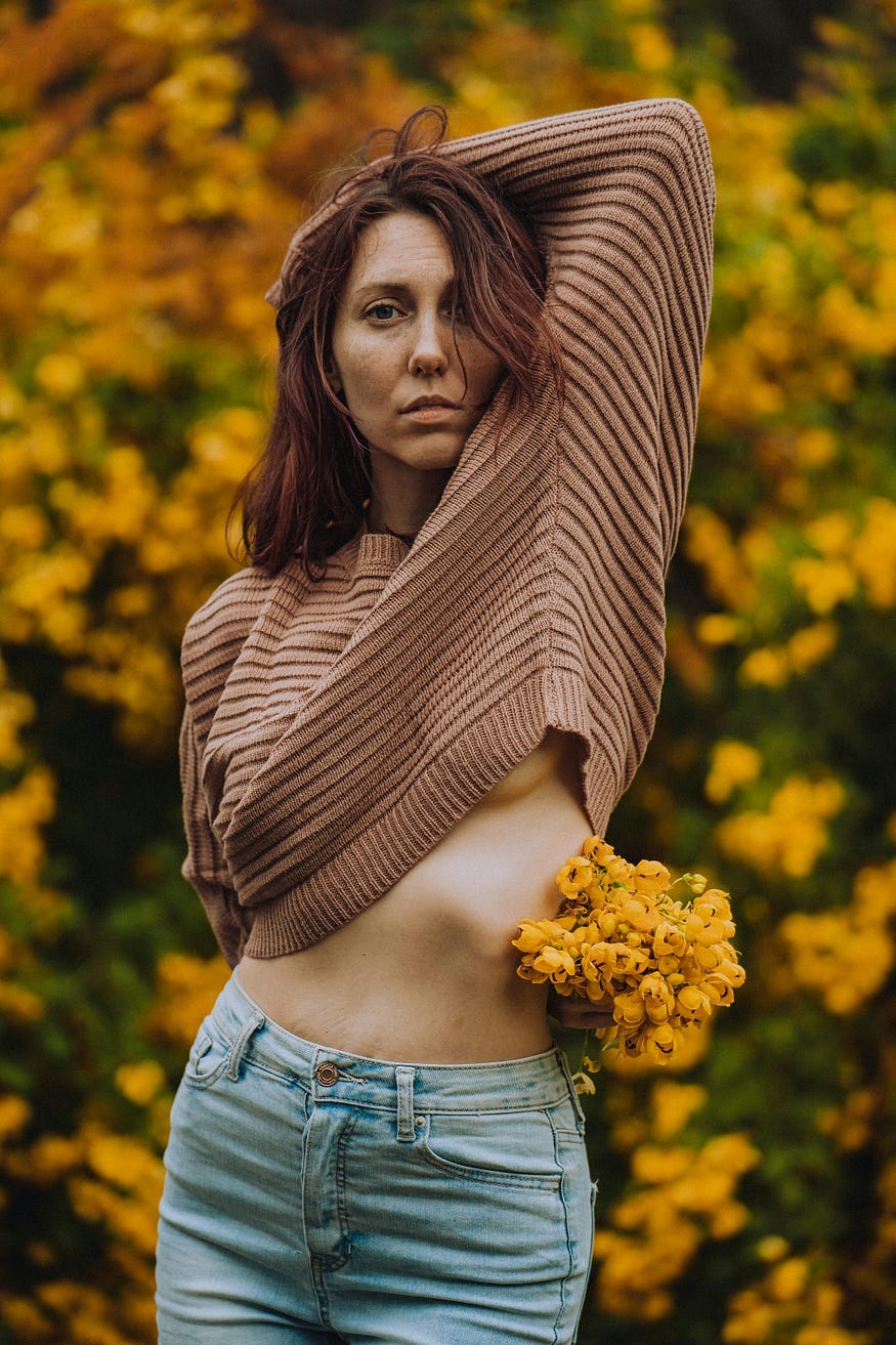 Woman lifting brown sweater outdoors