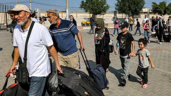 People carrying suitcases and bags enter the Rafah border crossing in the southern Gaza Strip on Nov. 1. 