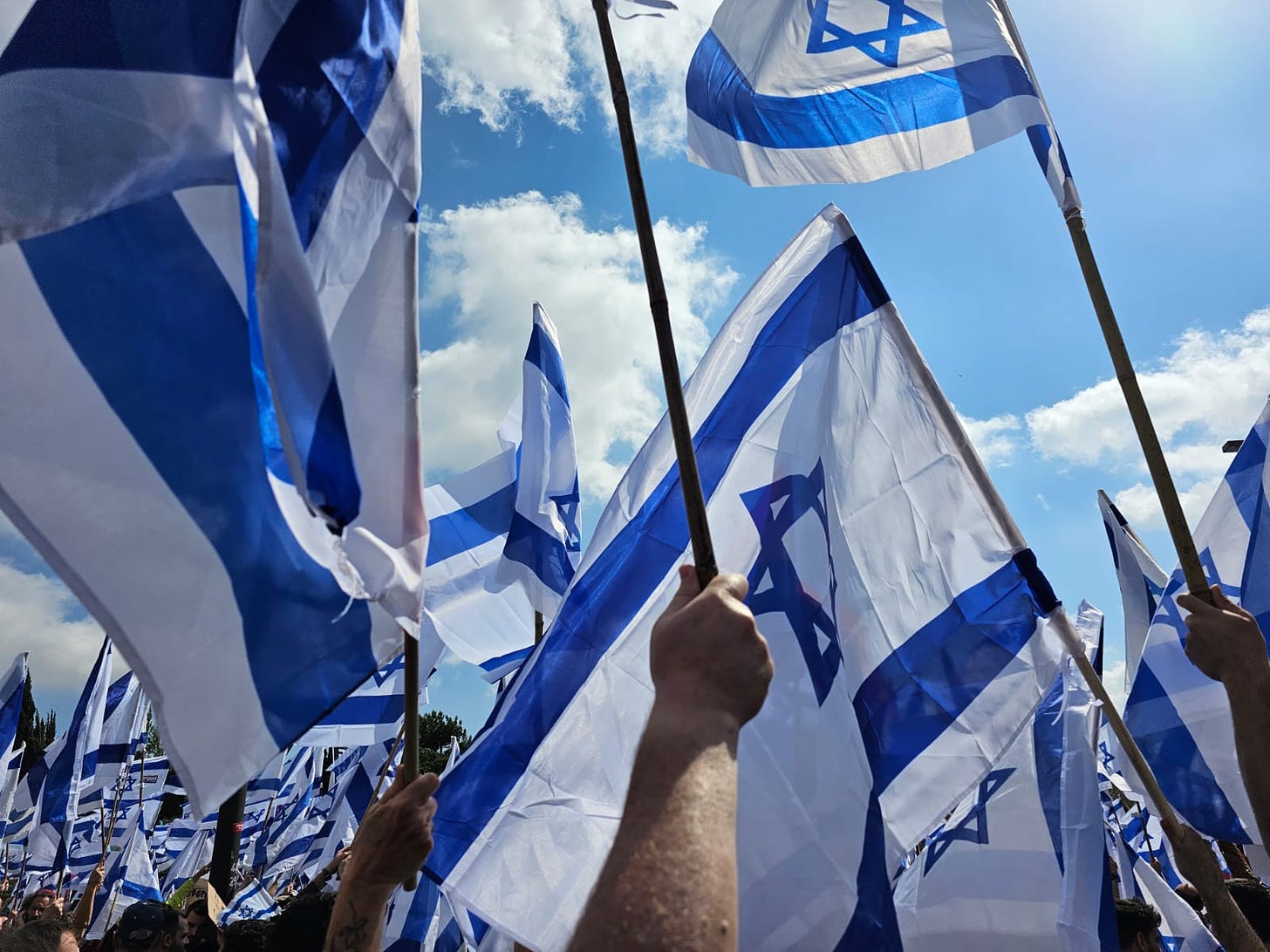 Israeli flags on blue sky background