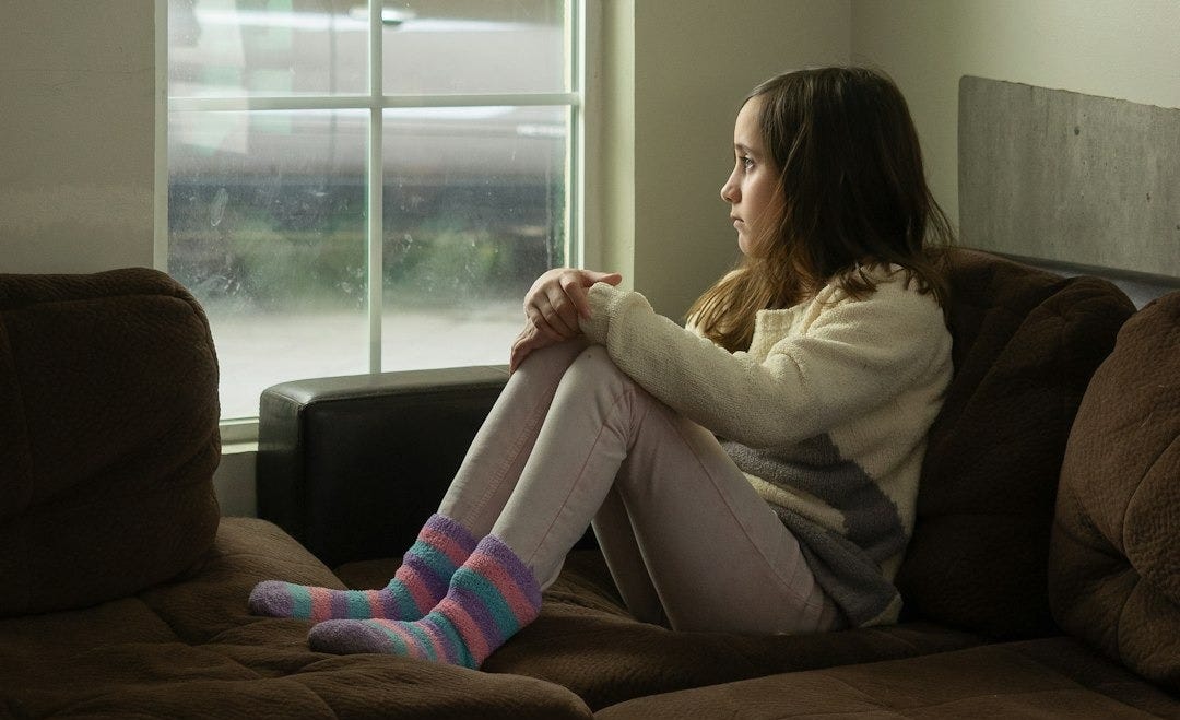 woman in white long sleeve shirt sitting on black couch woman in white long sleeve shirt sitting on black couch