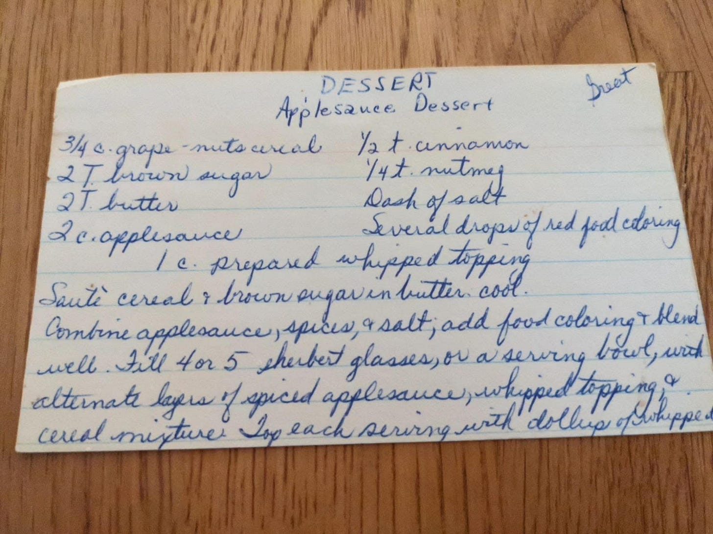 A white index card with the Applesauce Dessert recipe written on it in blue ink. 