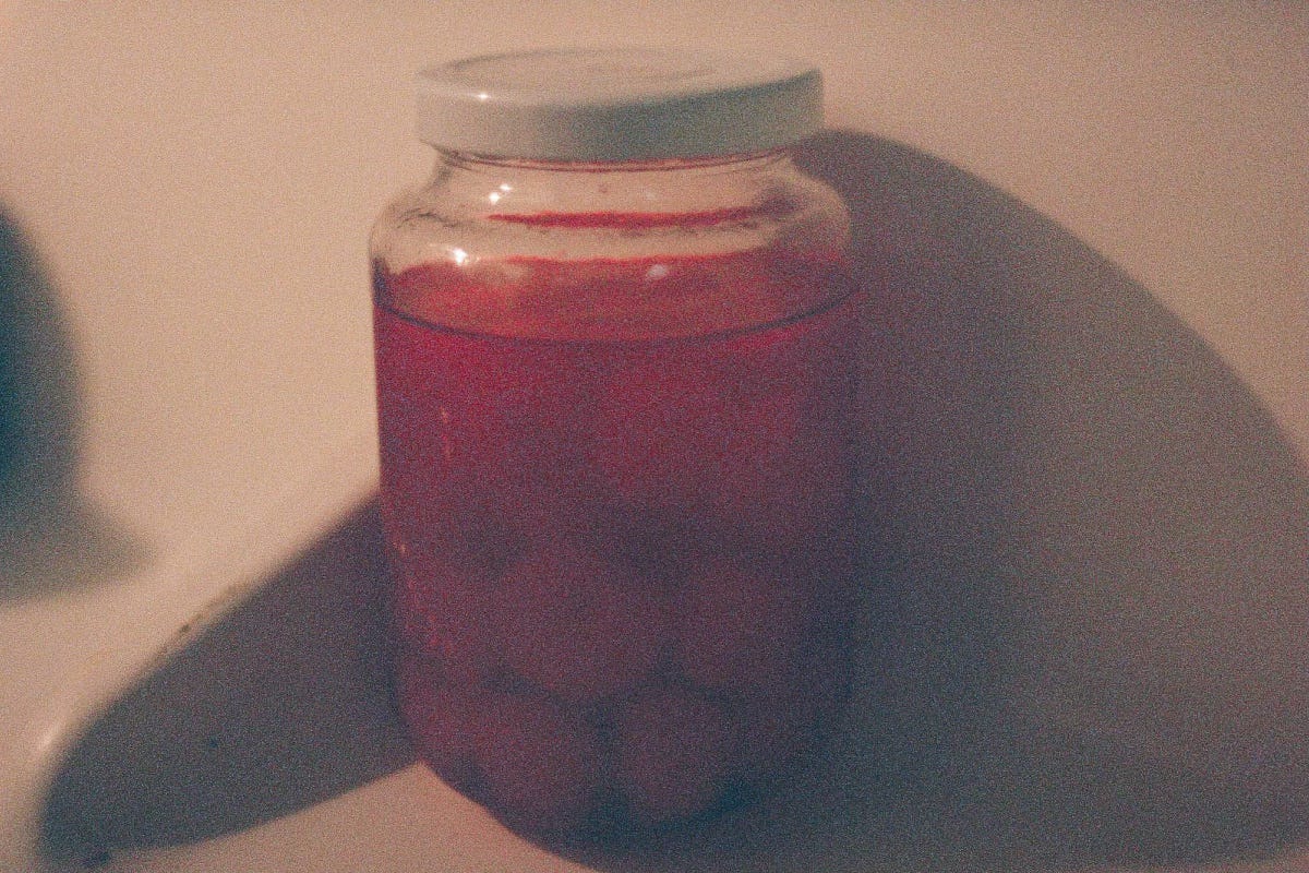 Photo of a jar of maraschino cherries on a refrigerator shelf