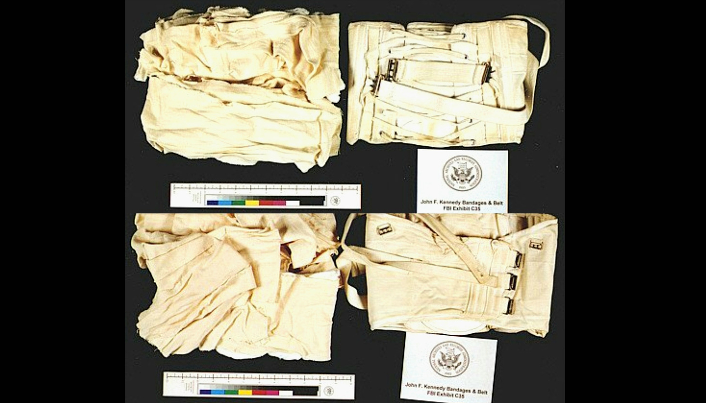JFK's back brace corset worn low over hips & pelvis, in an "Ace bandage"-type wrap around corset, legs, and upper thighs.