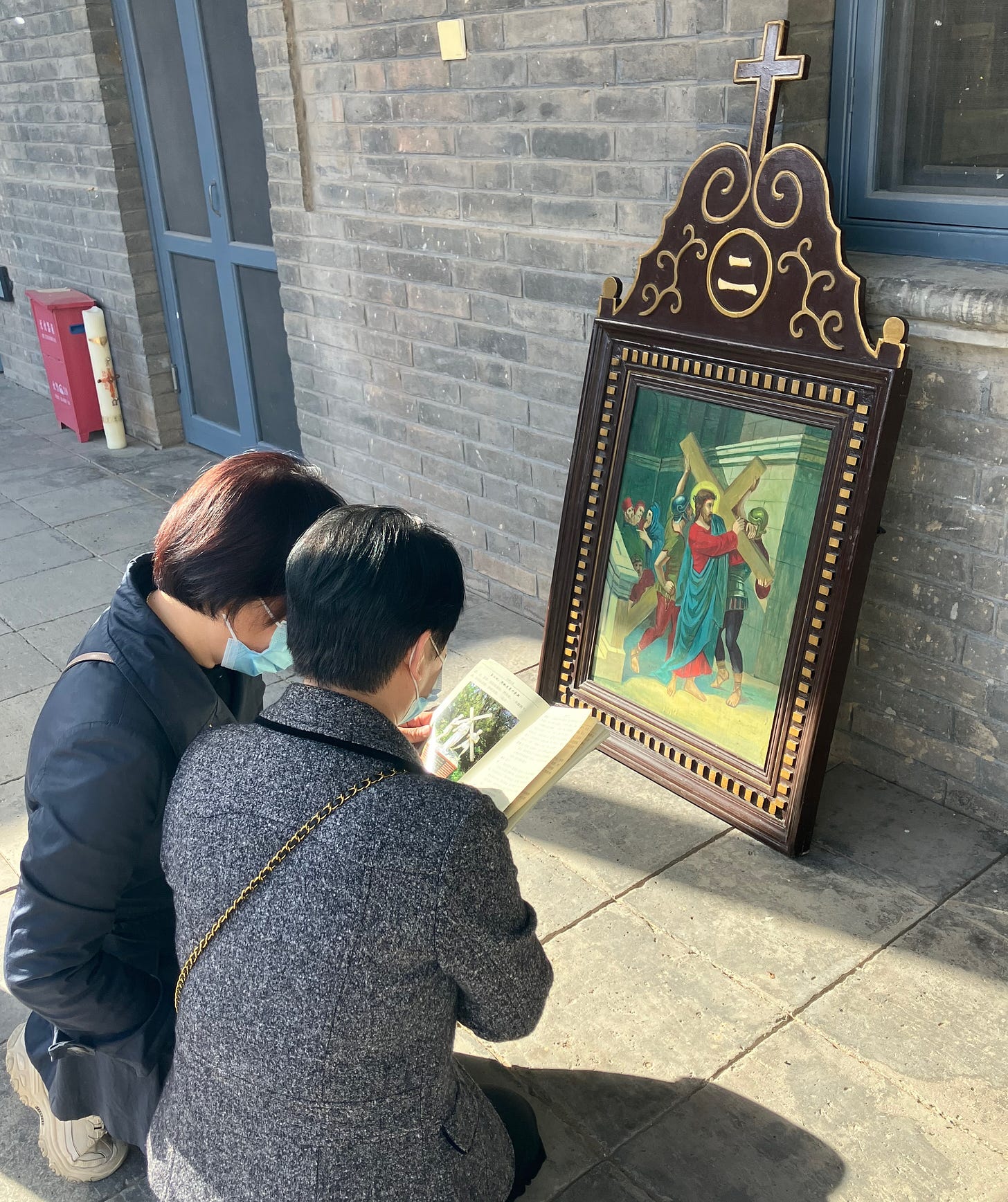 Believers continue praying the stations with a church booklet after the Good Friday procession ended.