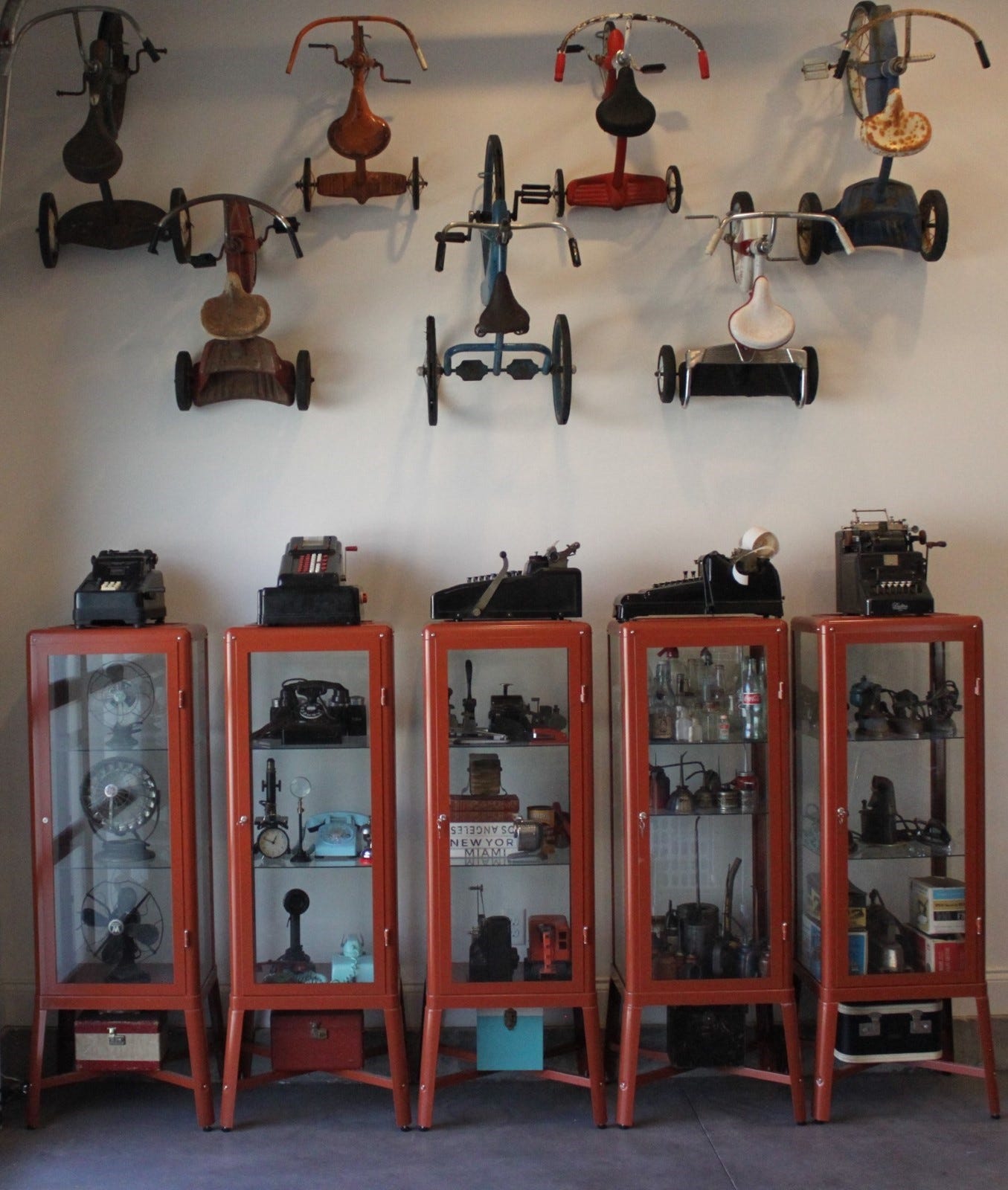 A row of red metal shelves with various objects on the wall

Description automatically generated