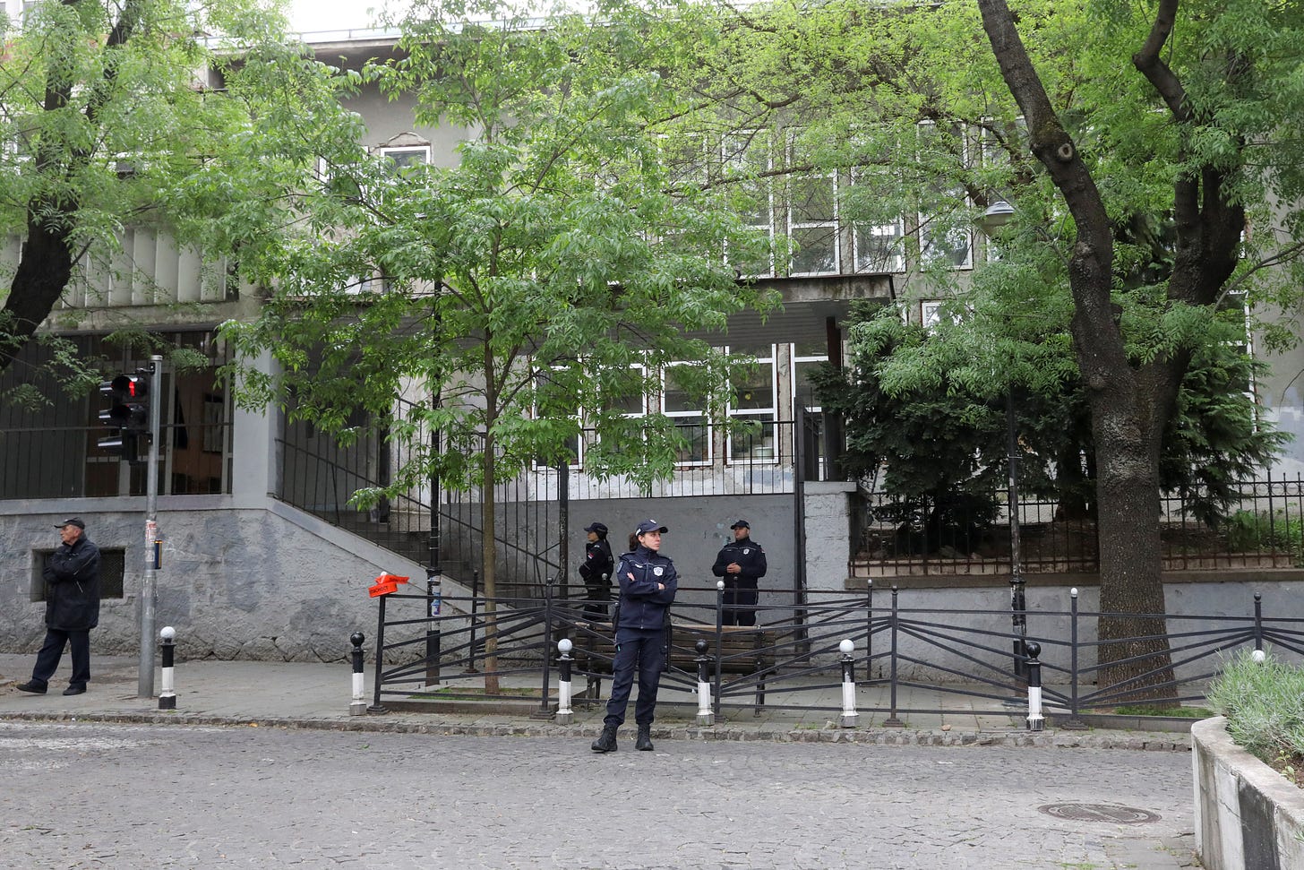 Police officers secure the area after a 14-year-old boy opened fire on other students and security guards at a school in downtown Belgrade