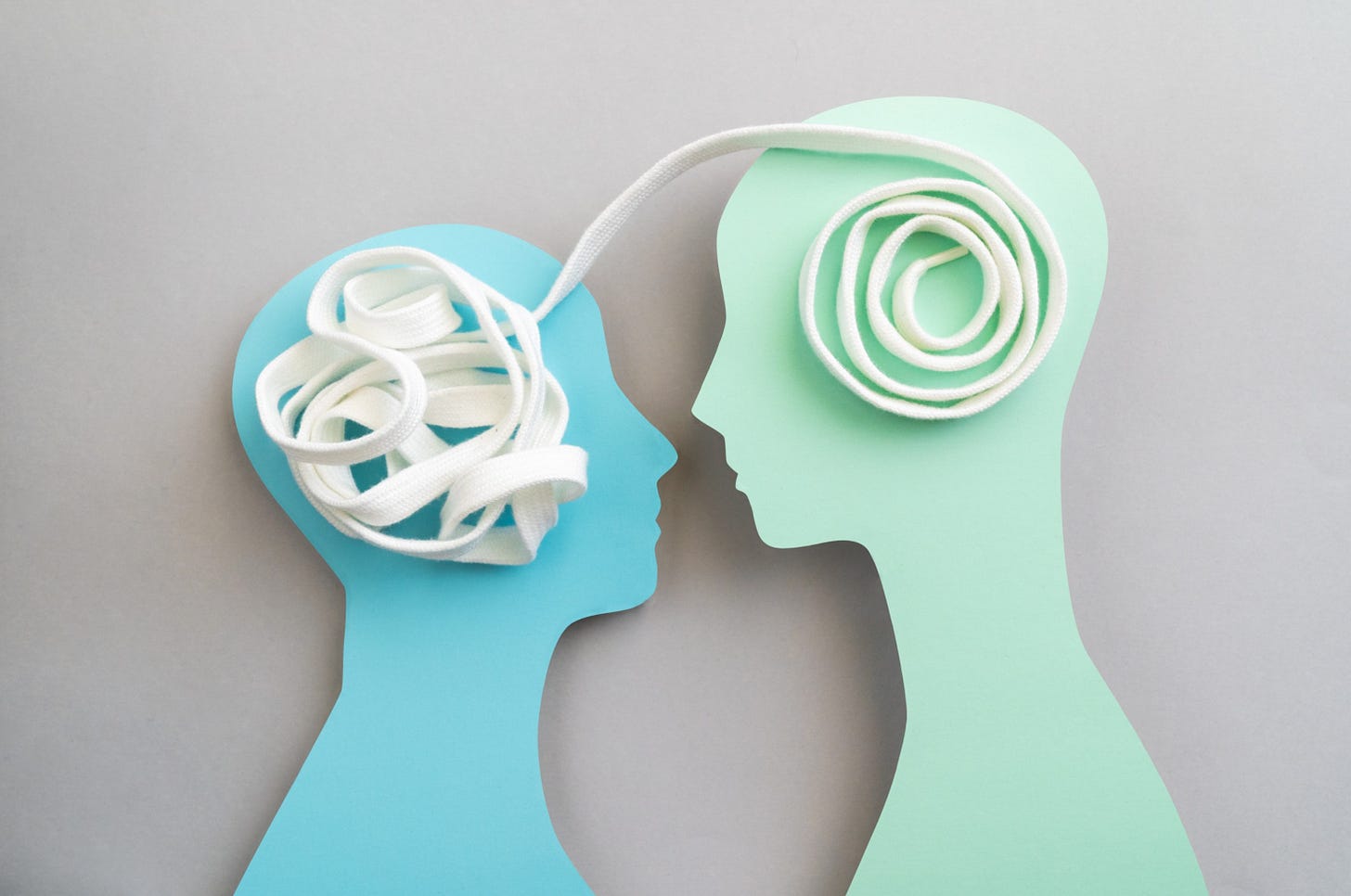 Graphics of two people's heads with tape winding between their brains.