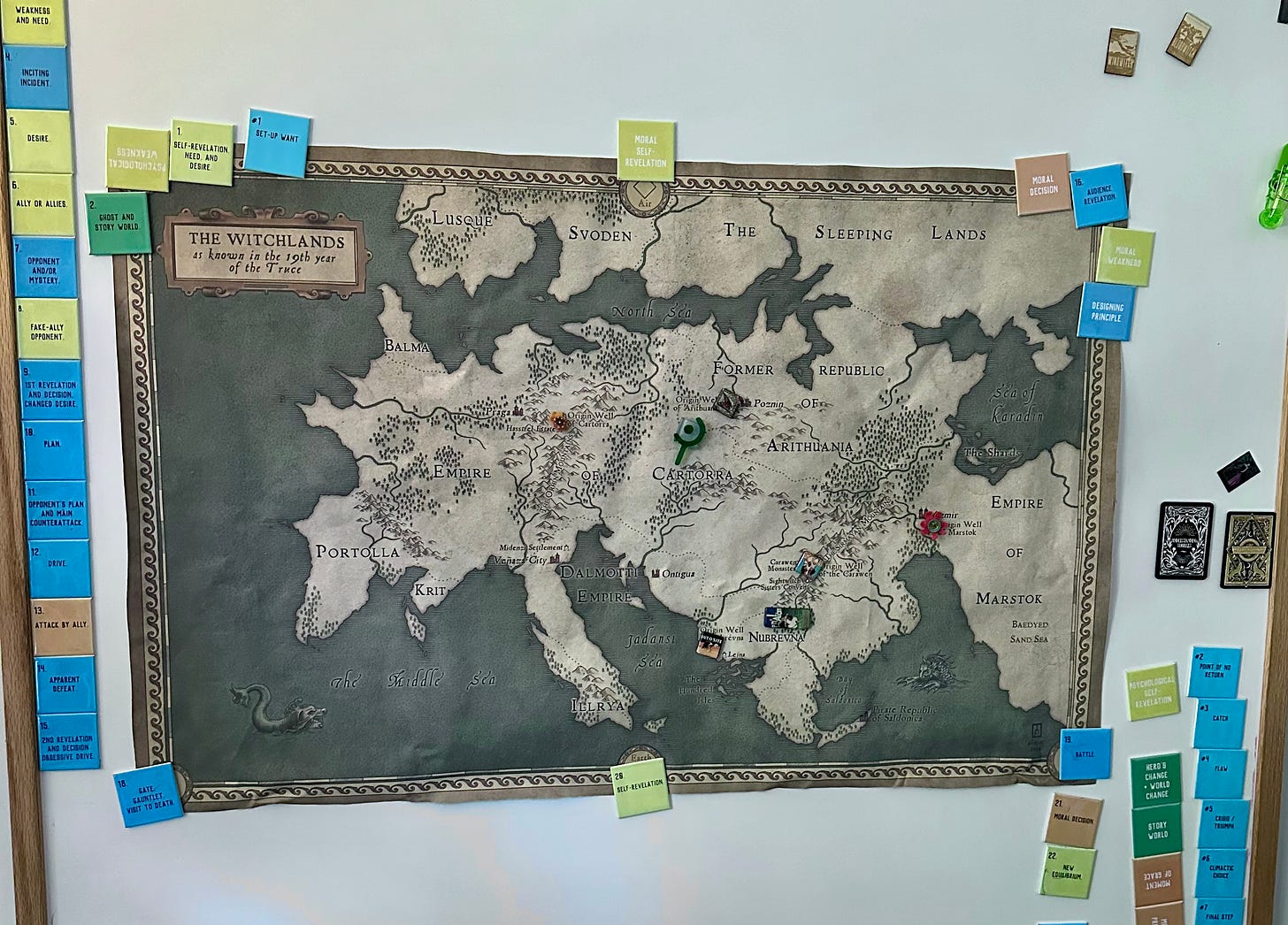 A huge map of the Witchlands on Susan's whiteboard, held down by magnets and with smaller magnets on different places across the map