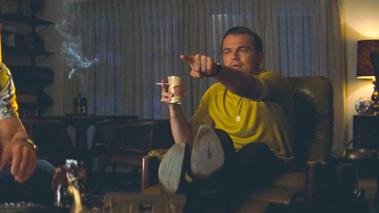 Leonardo Di Caprio smoking, drinking, and pointing.