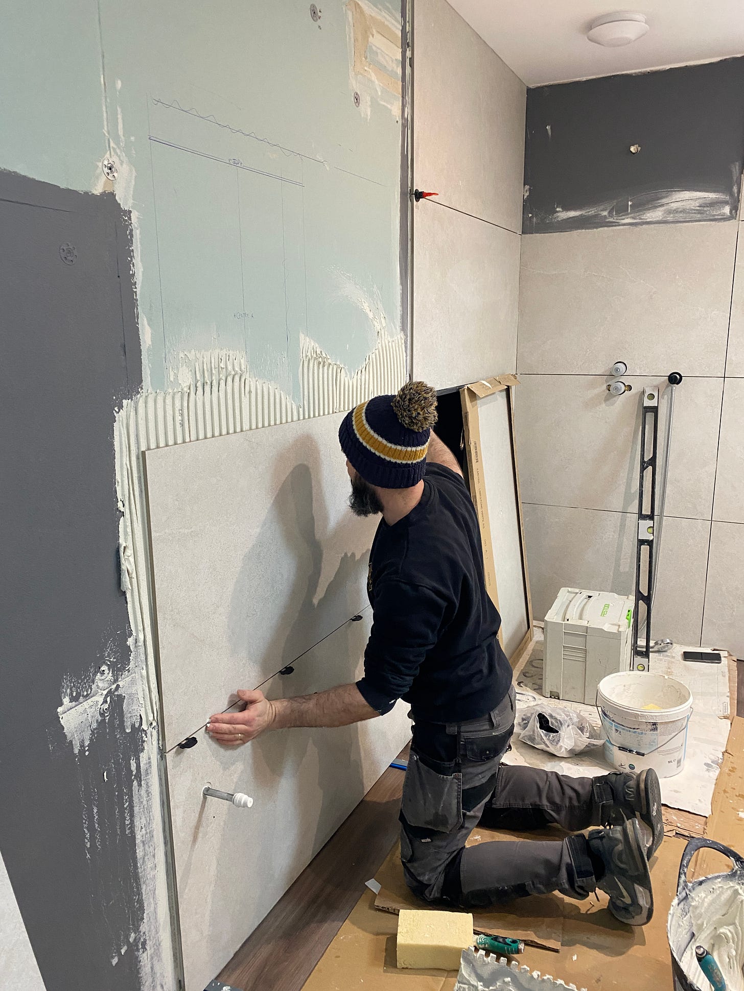 wall tiles being added by a man