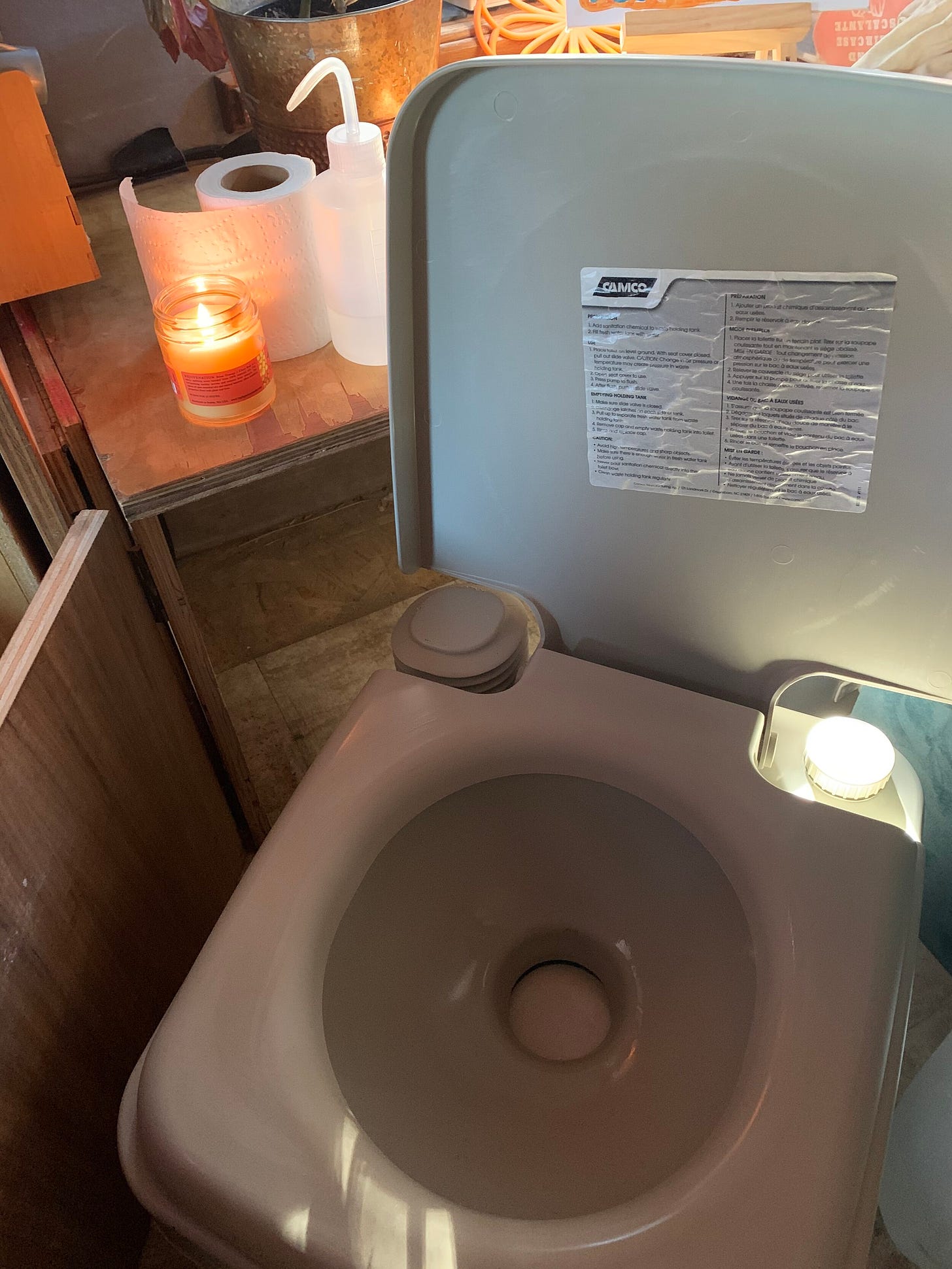 A plastic camping toilet inside a van