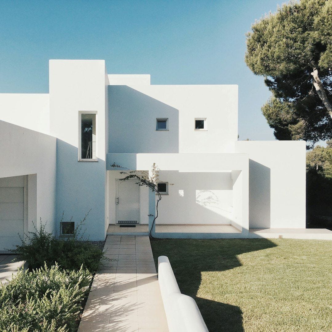 white concrete house near green tree during daytime white concrete house near green tree during daytime