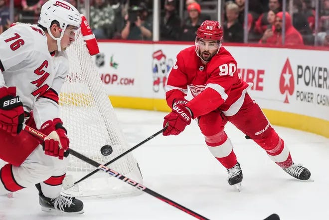 Joe Veleno fights for the puck behind the net during a game against the Carolina Hurricanes.