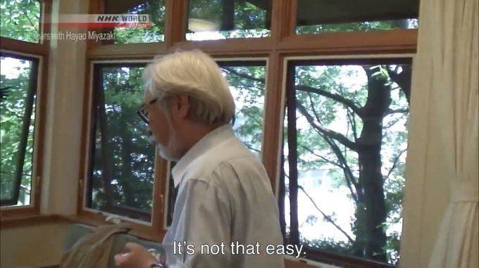 Imagen de Hayao Miyazaki diciendo "no es fácil" mientras reflexiono sobre la ilustración producto.