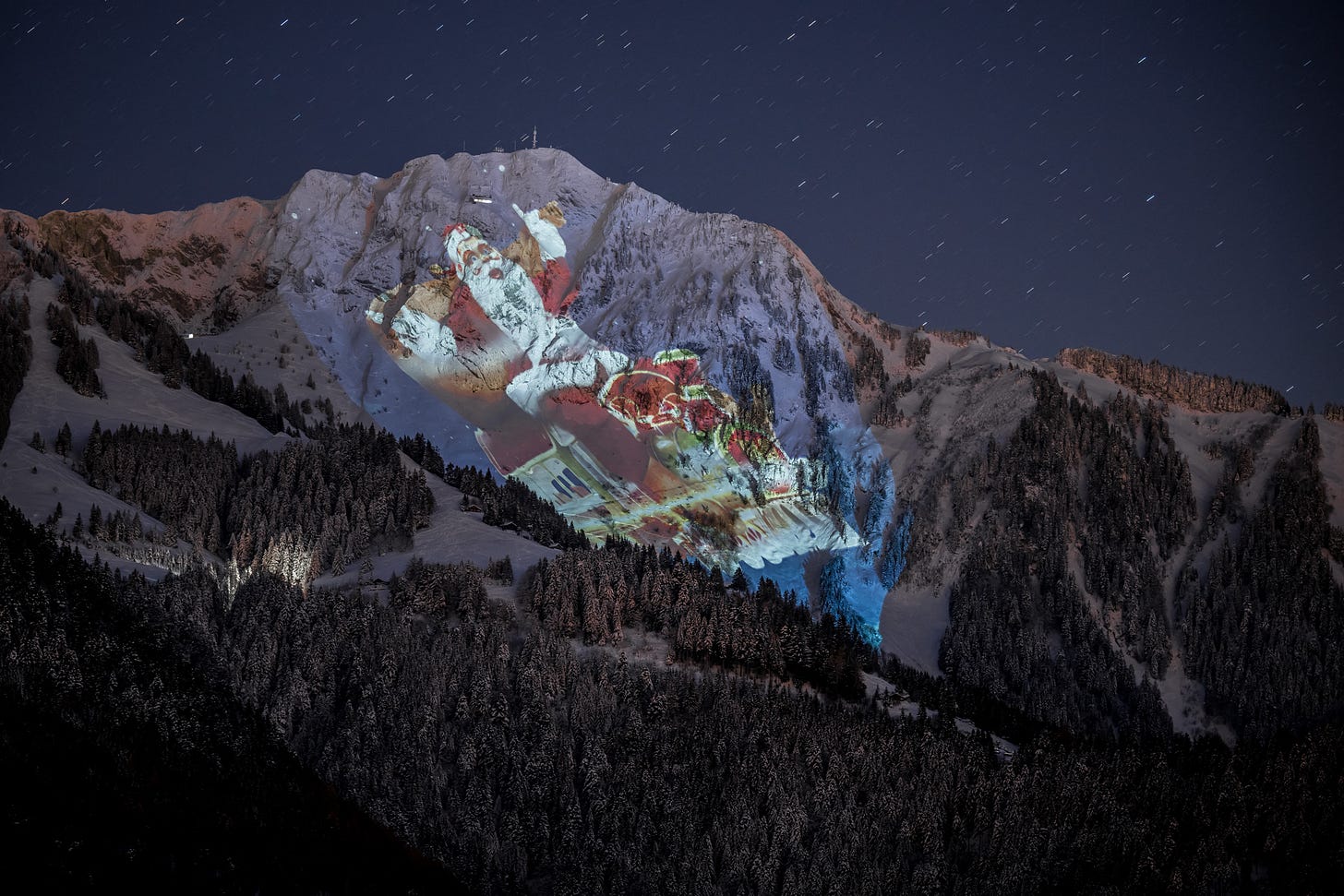 The Rochers-de-Naye mountain illuminated with a giant Santa by Swiss light artist Gerry Hofstetter on December 6, 2023. (Photo by Fabrice Coffrini/AFP via Getty Images)