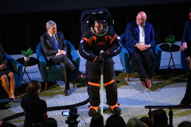 man on a stage in a dark spacesuit