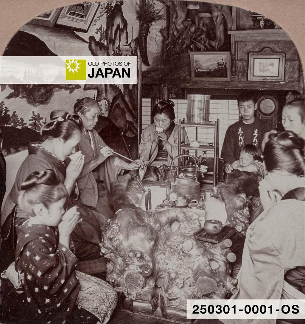 Japanese family sitting around an elaborate wooden hibachi, 1904