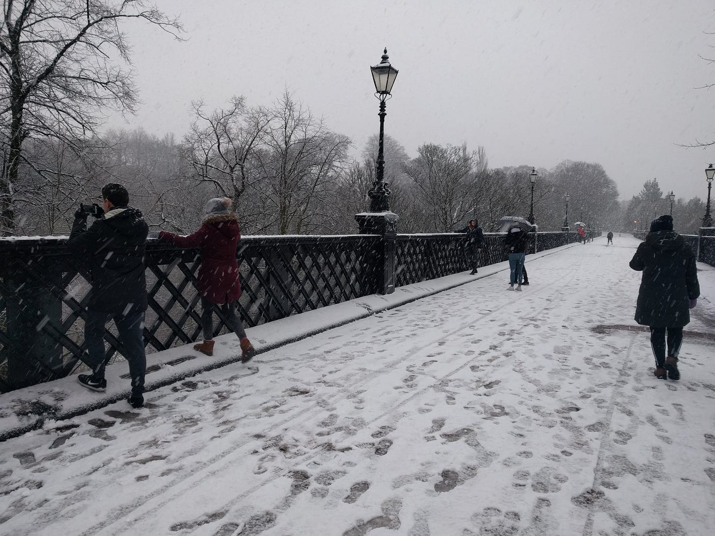 A snowy bridge. Many people are enjoying the bridge, including my then-housemates.
