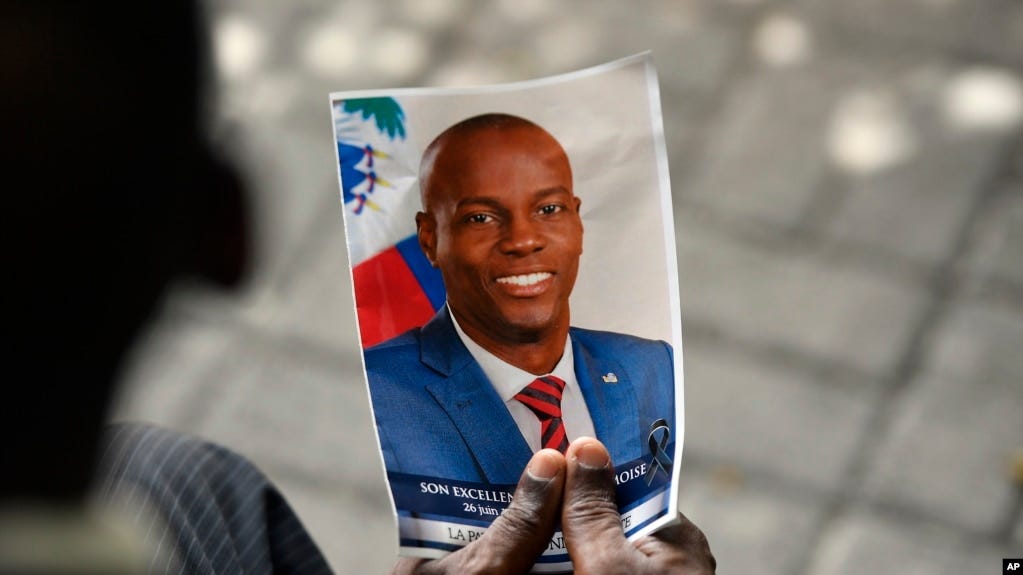 ARCHIVO - Una persona sostiene una fotografía del fallecido presidente haitiano Jovenel Moise durante su ceremonia conmemorativa en el Museo Nacional del Panteón en Puerto Príncipe, Haití, el 20 de julio de 2021.