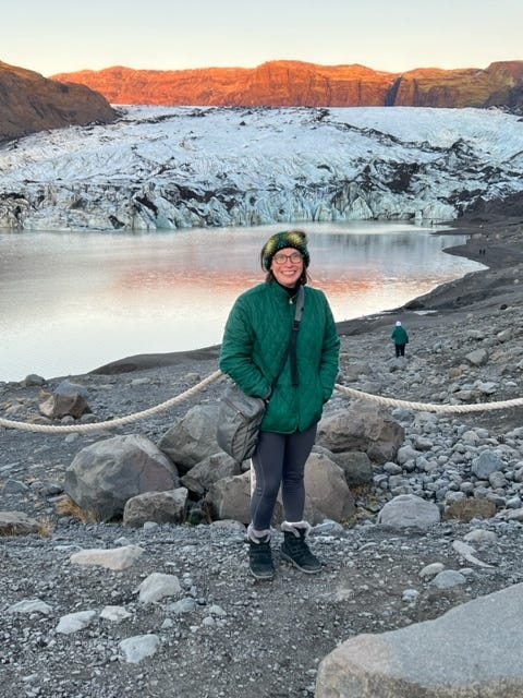 Jessica in front of a glacier in Iceland at sunset.