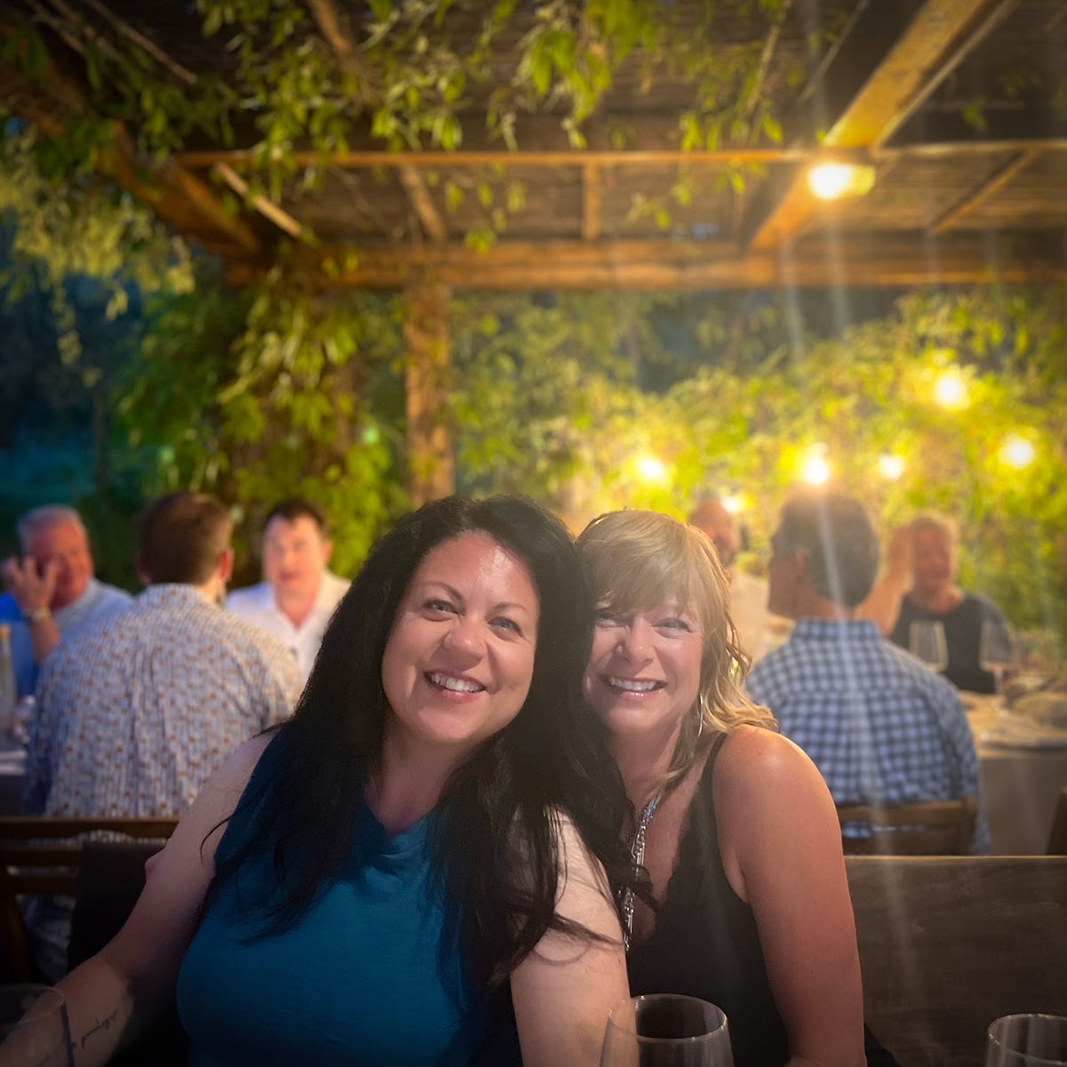 Two friends sharing a meal together on an outdoor patio.