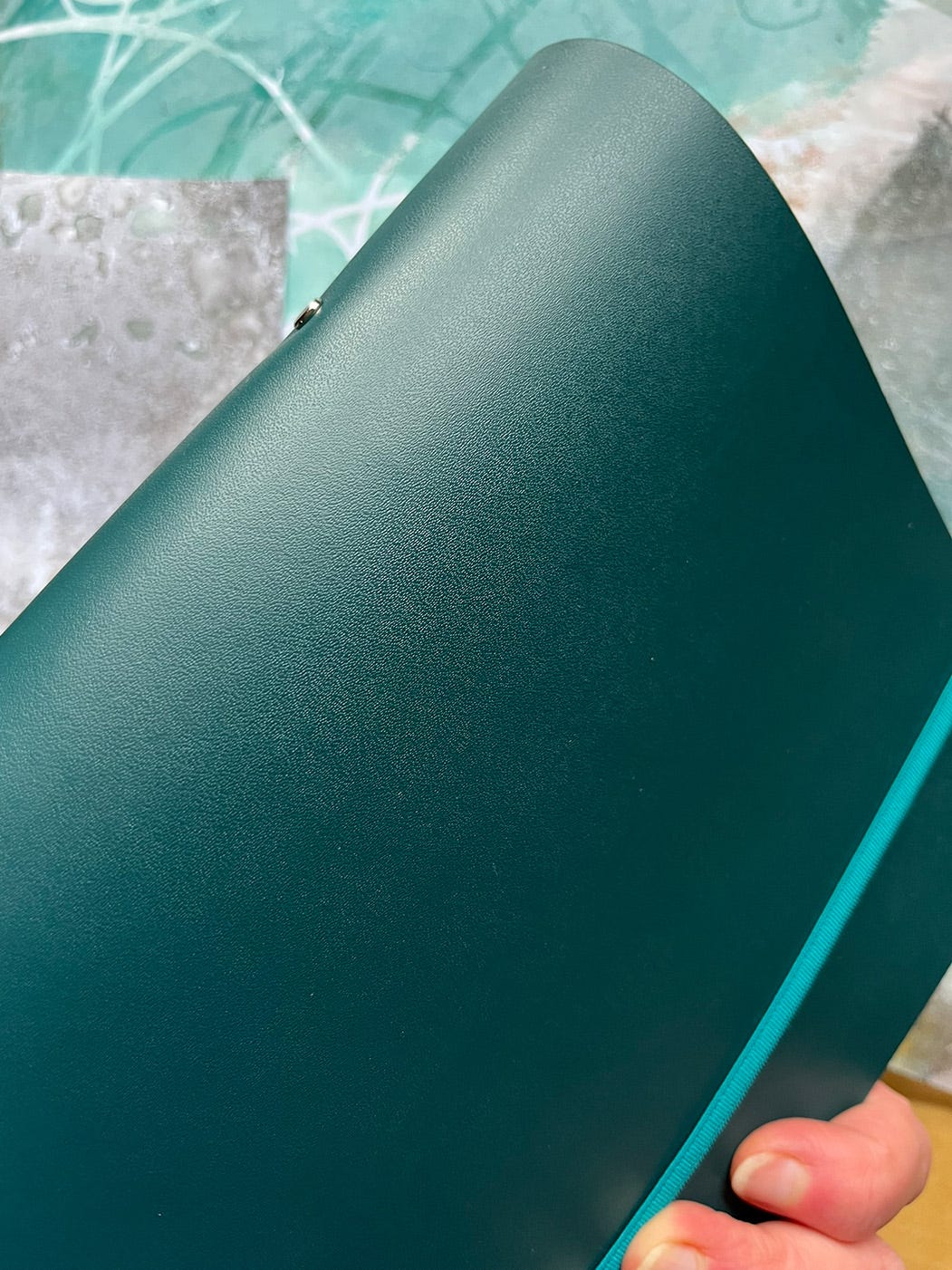 A small, beautiful, ring binder in petrol coloured leather