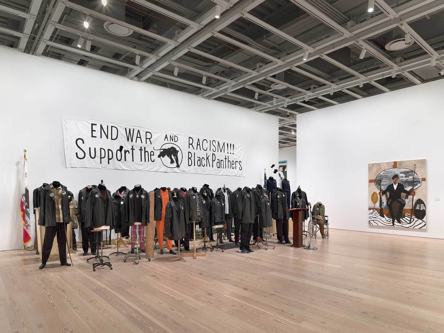 A group of black clothed mannequins and a Black Panthers banner above.  