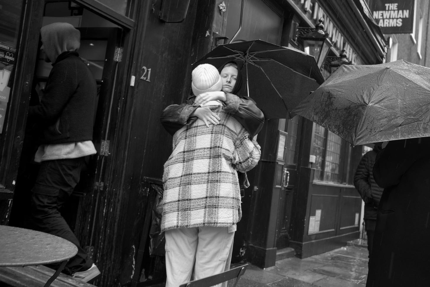 Two people hug outside a London pub