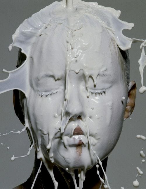 This may contain: a woman with her face covered in milk