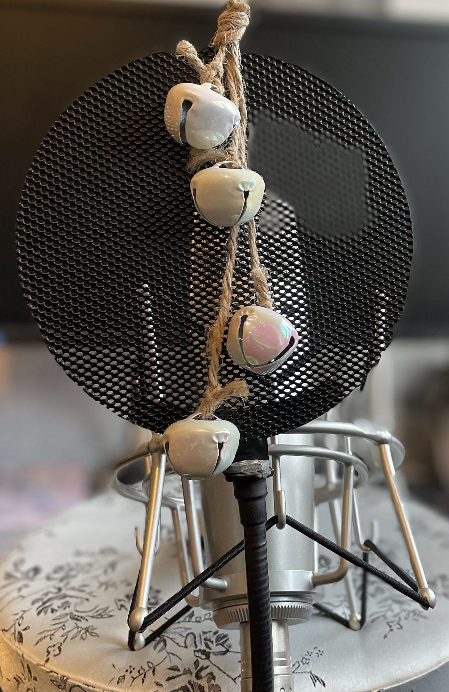 Christmas decorative bells hanging from the pop shield in front of a microphone