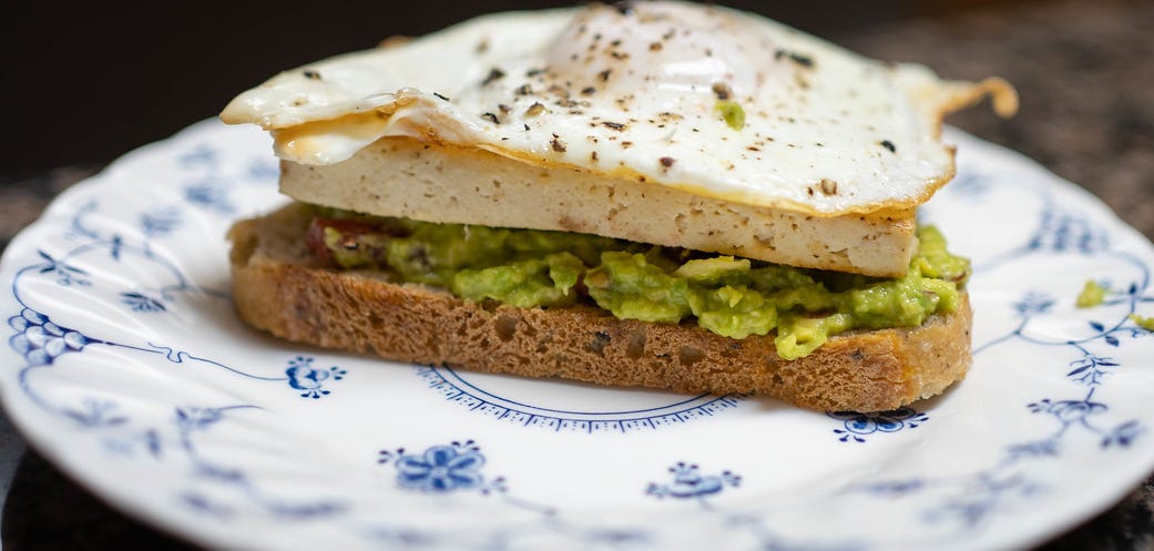A photo of avocado toast with an egg on top