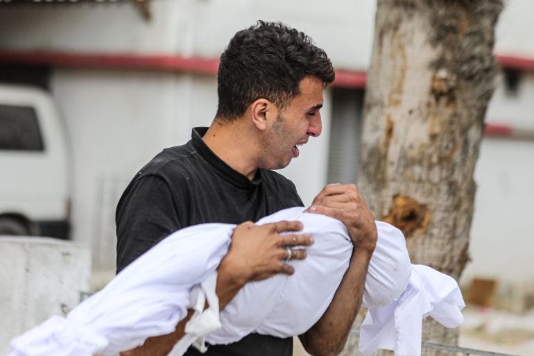 A Palestinian holds the shrouded body of a relative Israel killed in attacks on Gaza City, on May 16, 2024 [Dawoud Abo Alkas/Anadolu]