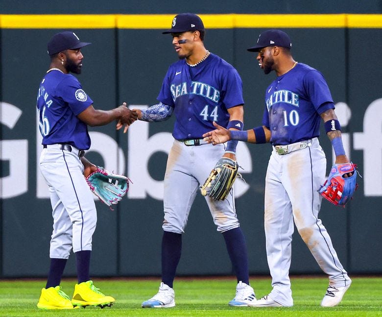 Seattle Mariners&#8217; Randy Arozarena, left, celebrates with Julio Rodriguez and Victor Robles after a win over the Texas Rangers in a baseball game, Friday, Sept. 20, 2024, in Arlington, Texas. (Richard W. Rodriguez / AP)