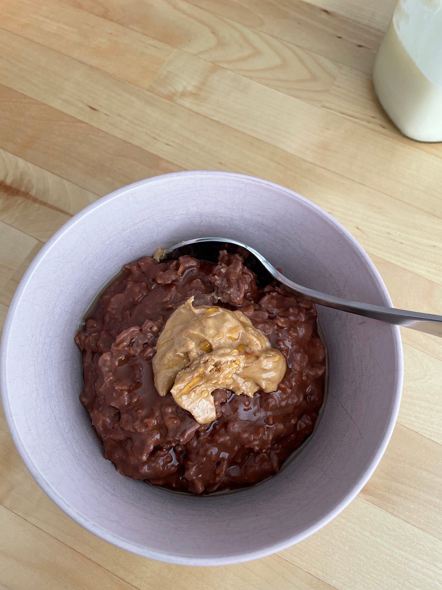Breakfast is a bowl of cocoa porridge with almond butter from Genius Recipes.