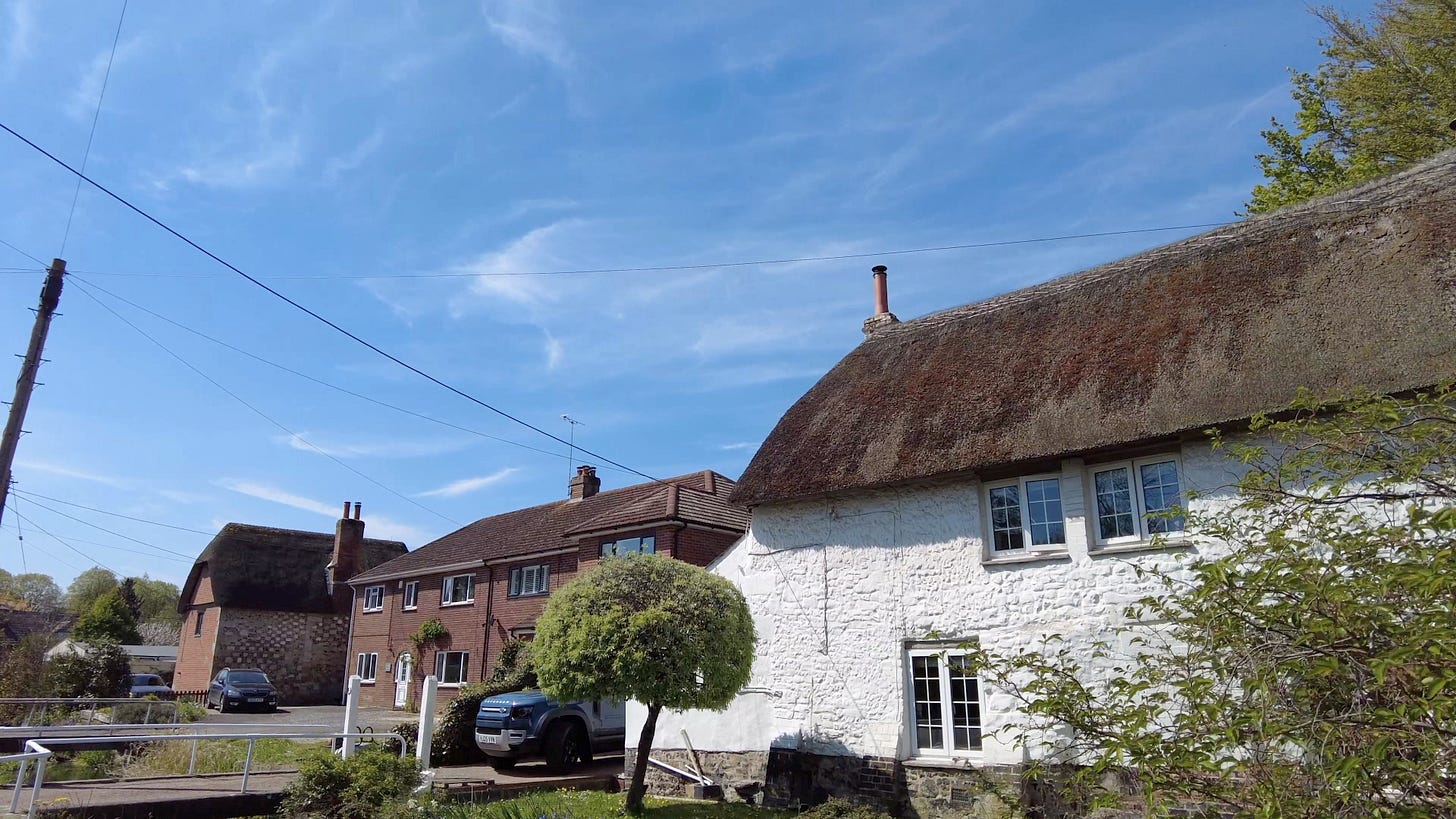 A thatched cottage with the River Till in front.