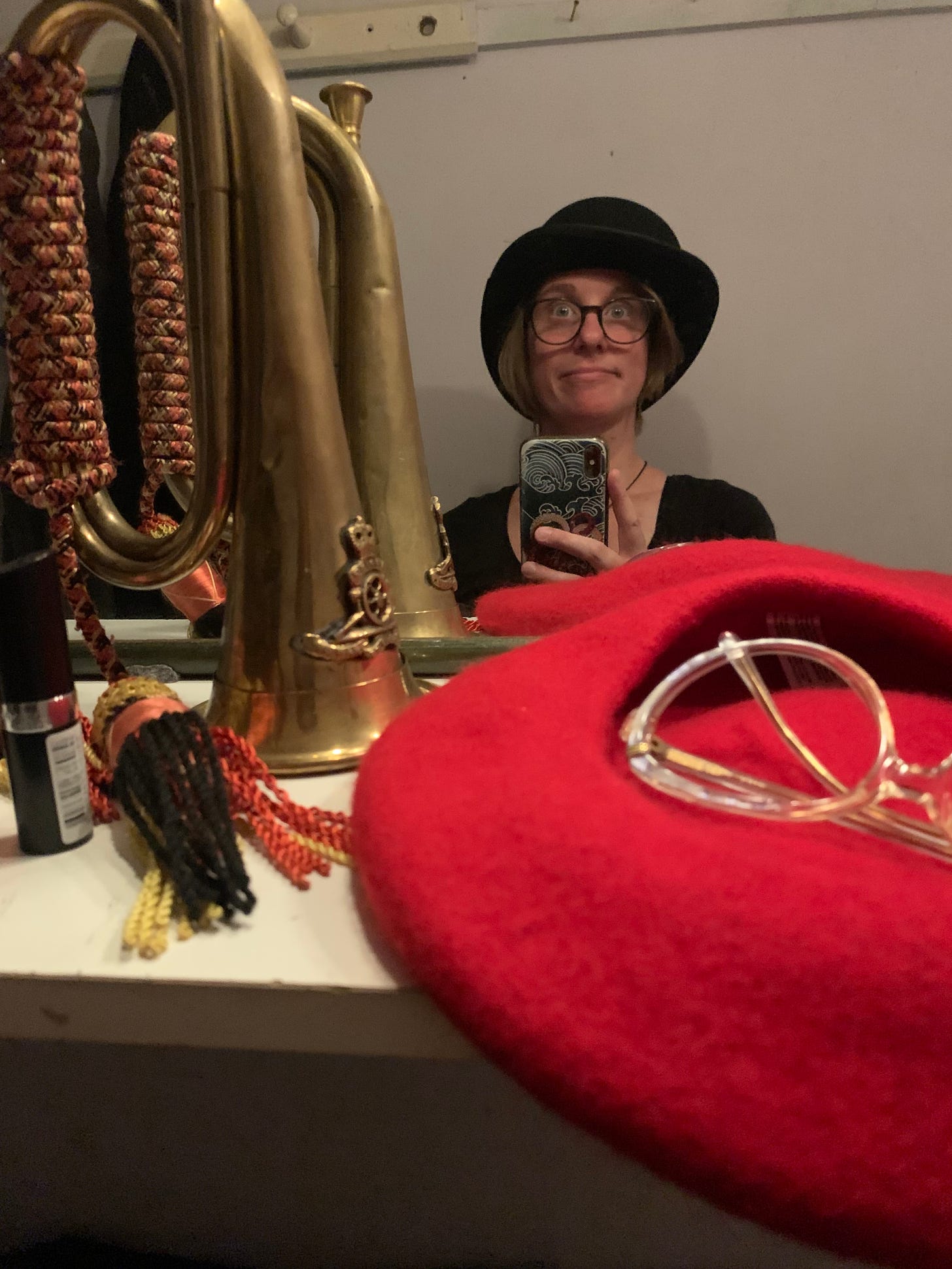 A photo of Jo Gatford backstage at Brighton Little Theatre wearing a black bowler hat and making a silly face