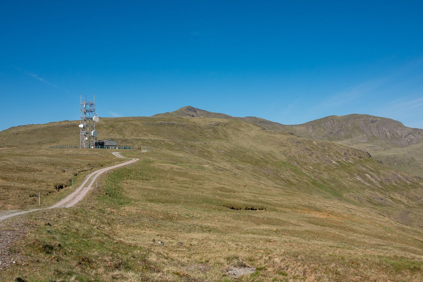 The stony track ends at a communications mast, beyond which I climbed up on to Mainnir nam Fiadh (on the left) before a ridge walk to Dun da Ghaoithe (on the right)  © Felicity Martin