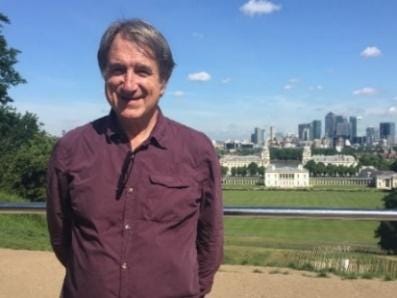 Professor David Hall stands in front of a park with tall buildings in the background