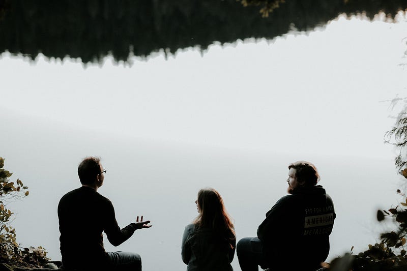 People talking near a lake