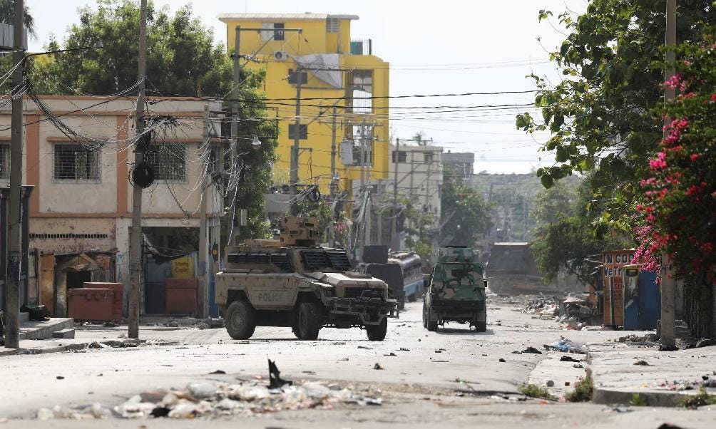 Military vehicles driving down a street

Description automatically generated