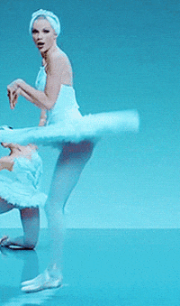 a gif of taylor swift from the shake it off video clip, wearing a blue leotard and tutu in a blue room, dance-jumping backwards like a bunny (aka showing off how i would awkward-happy dance when i get your reply)