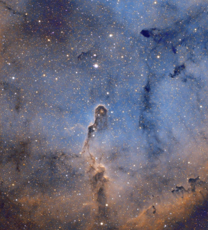 Elephant Trunk Nebula, grey, blues, golden colored sky, filled with stars and the cosmic dust towering