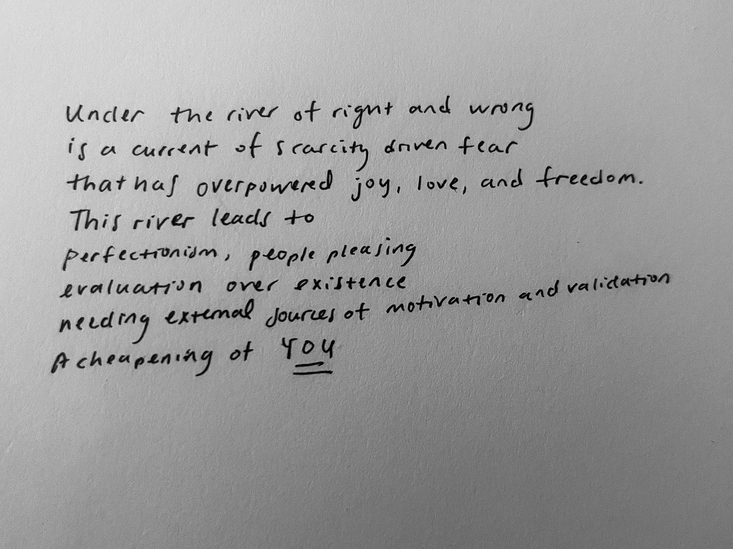 a black and white photo of the following poem: Under the river of right and wrong is a current of scarcity driven fear  that has overpowered joy, love, and freedom.  This river leads to  perfectionism, people pleasing evaluation over existence external sources of motivation and validation a cheapening of you