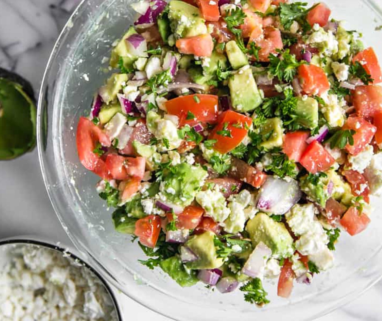 Bowl with tomato, avocado, and feta salad/dip.