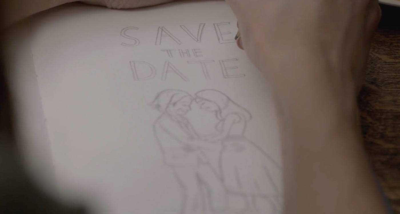 Movie still from Save the Date. A hand draws a wedding save the date card, with two people dancing.