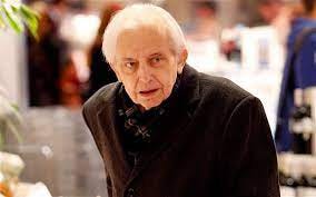 80-year-old Cornelius Gurlitt with white hair in a black coat and wool scarf.