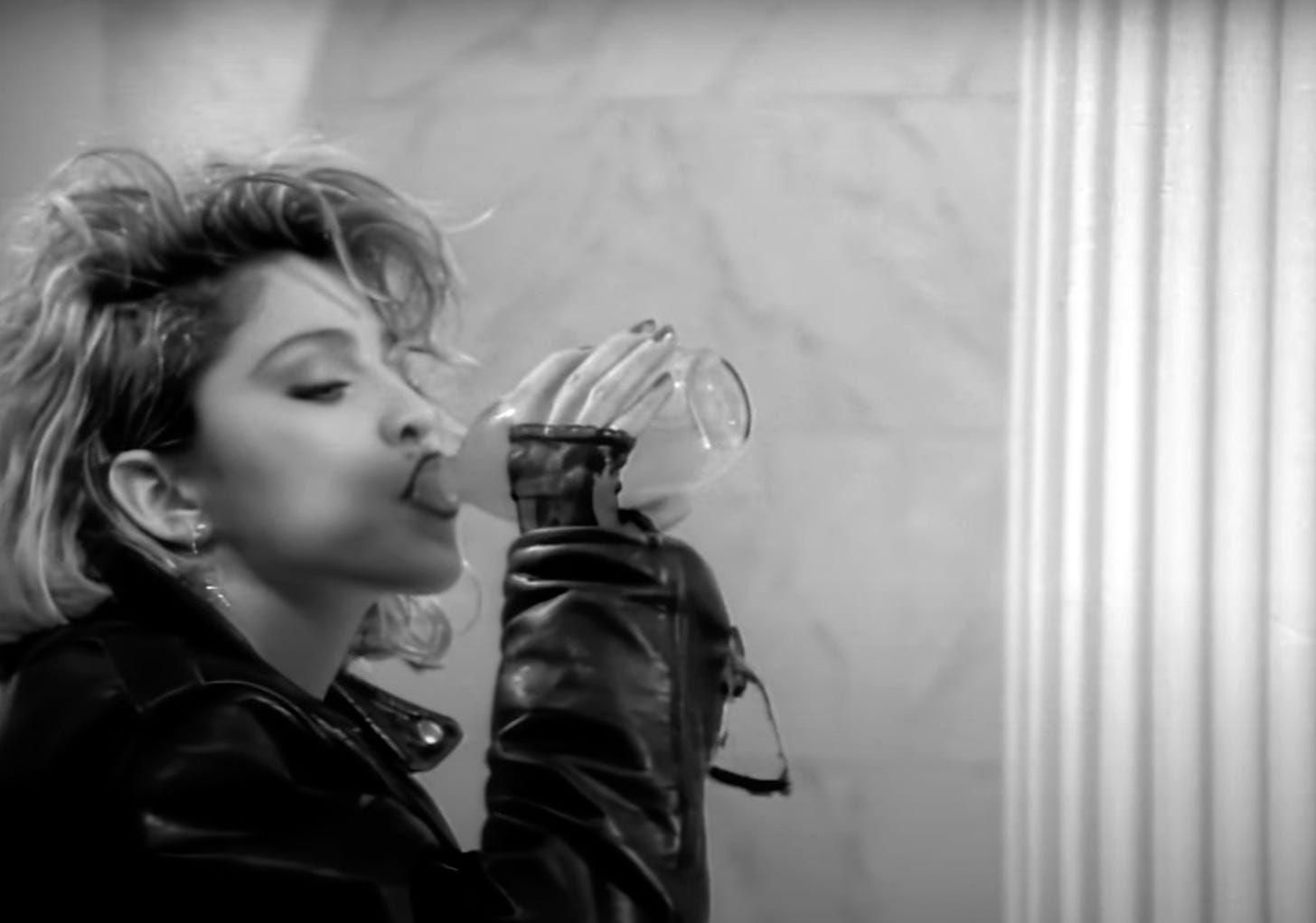 Still from the Borderline video featuring Madonna drinking from a bottle 