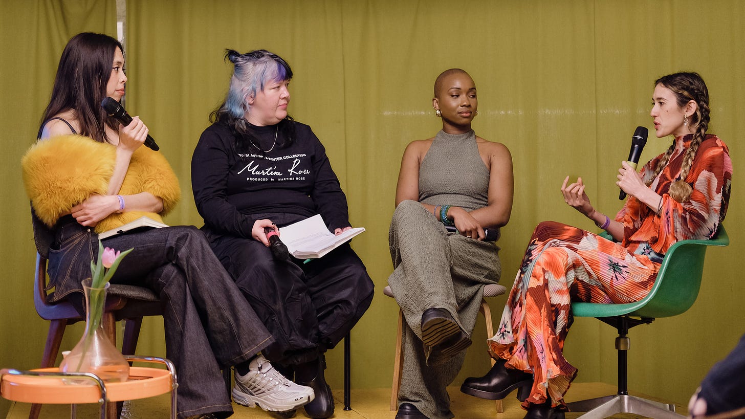 Photograph of four women sitting on chairs for a panel discussion together